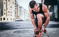 Corredor masculino concentrado atando los cordones en un entorno urbano