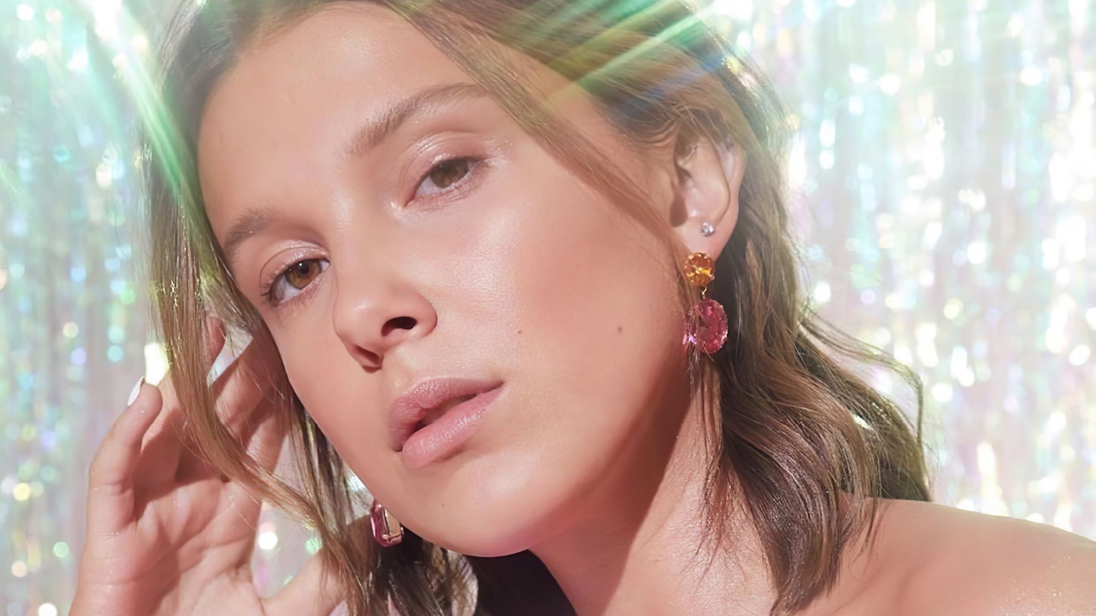 Un primer plano de una mujer con un vestido rojo y pendientes (millie bobby brown, británico, actriz, celebridad, chicas)