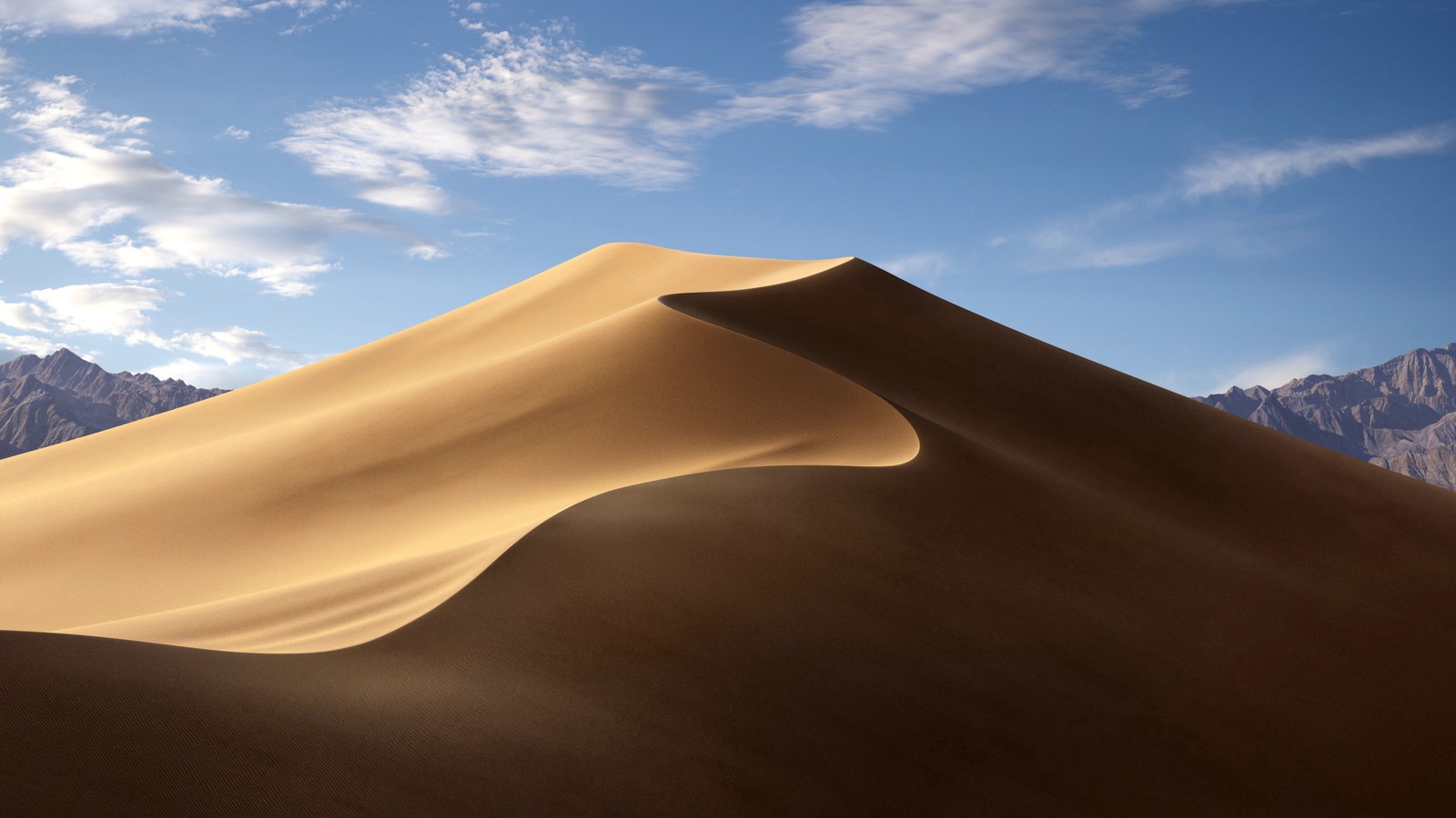 Uma duna de areia no deserto com montanhas ao fundo (macbook, macbook pro, maçã, imac pro, macos mojave)