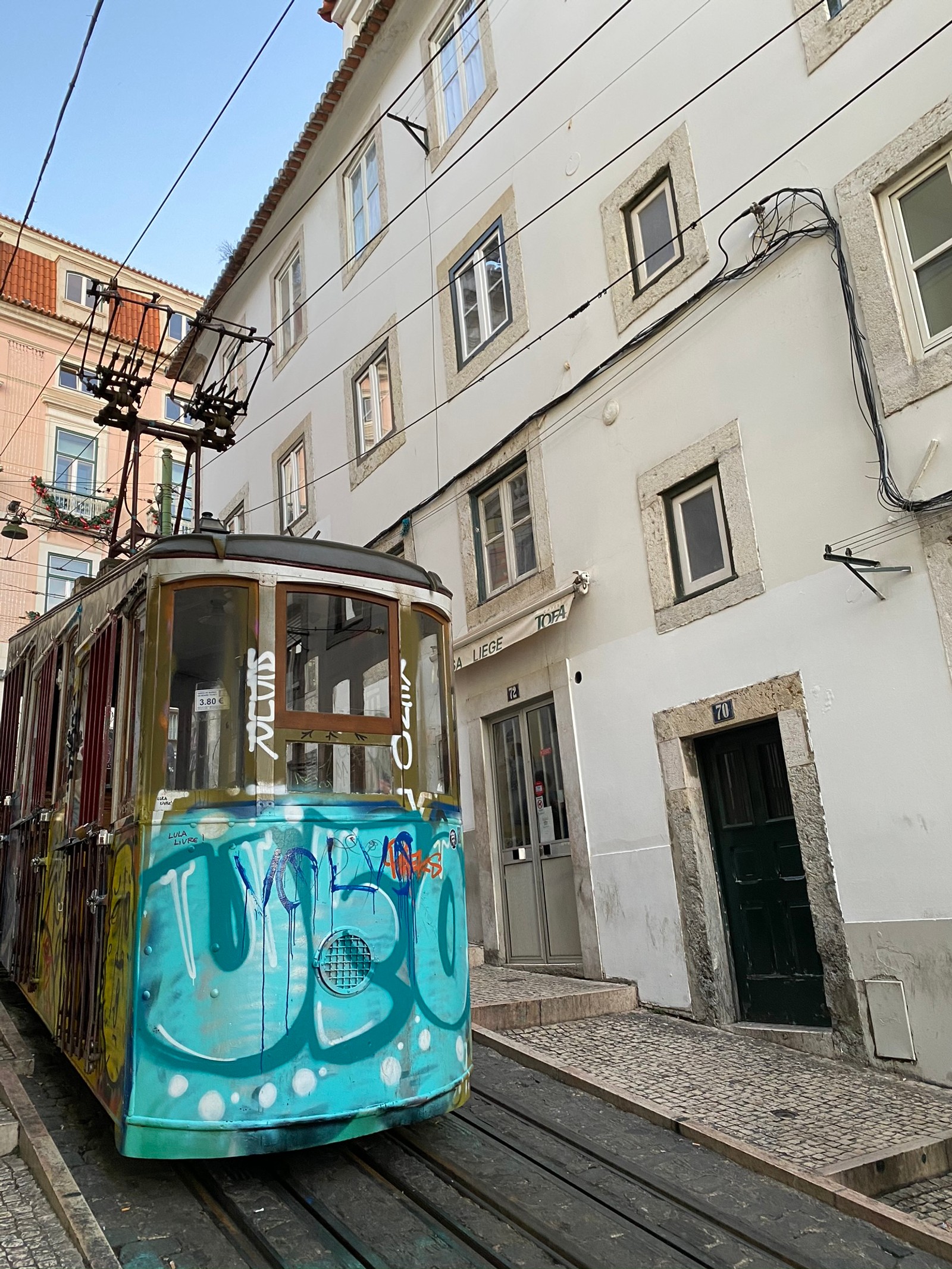 Um bonde colorido árabe em uma rua estreita da cidade (transporte público, vagão de trem, transporte, janela, vizinhança)