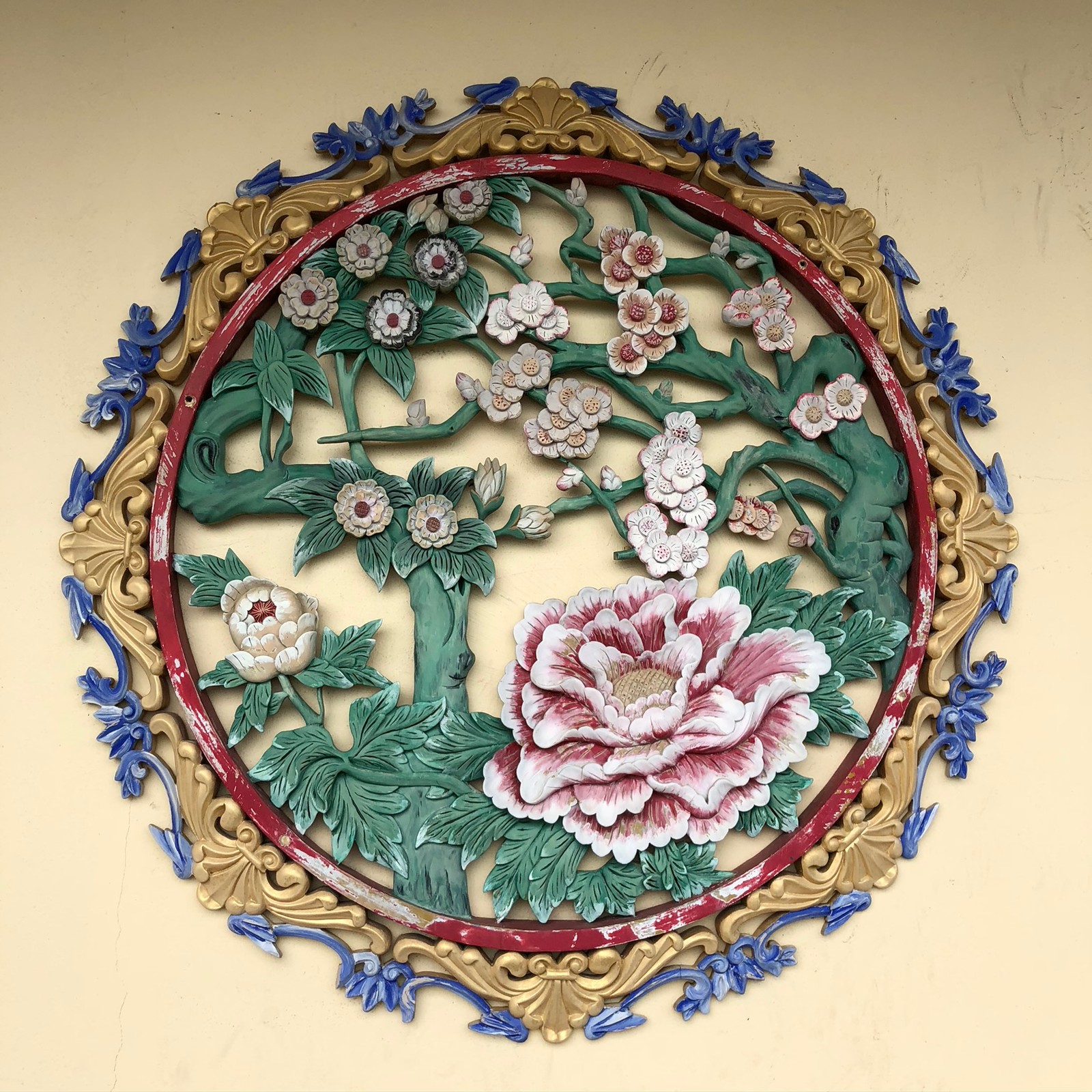 There is a decorative wall hanging with flowers and leaves (gown, art, dishware, creative arts, serveware)