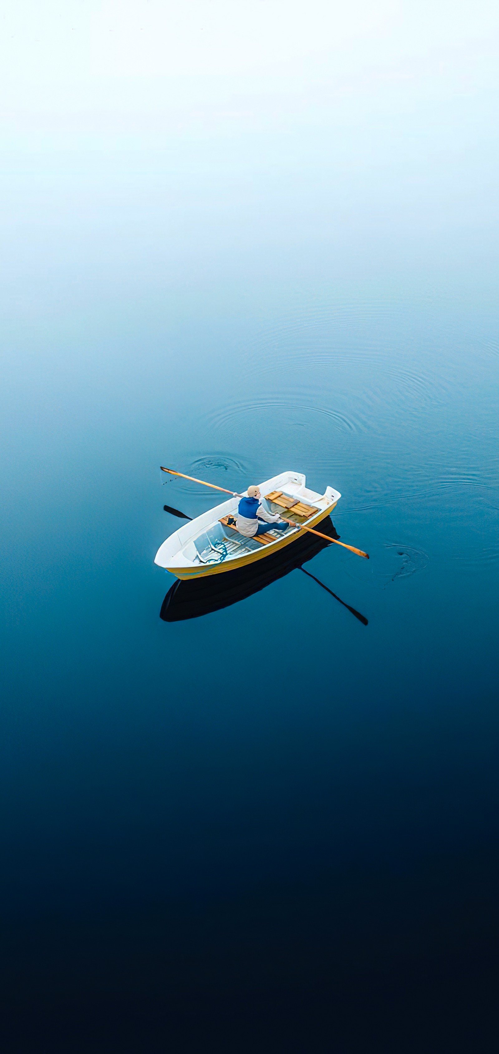 Um pequeno barco flutuando na água com remos (reflexo, transporte aquático, recursos hídricos, água, barco)