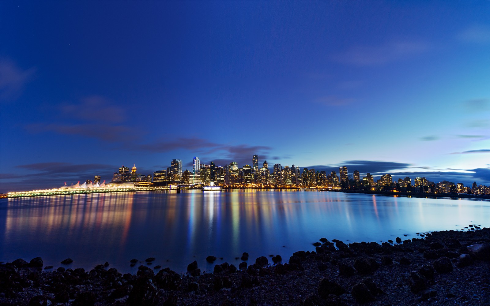 Blick auf die skyline einer stadt bei nacht von der anderen seite eines sees (stadt vancouver, vancouver city, british columbia, dämmerung, stadtbild)