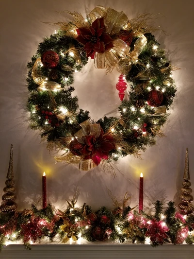 Corona navideña festiva y decoración de chimenea con luces cálidas