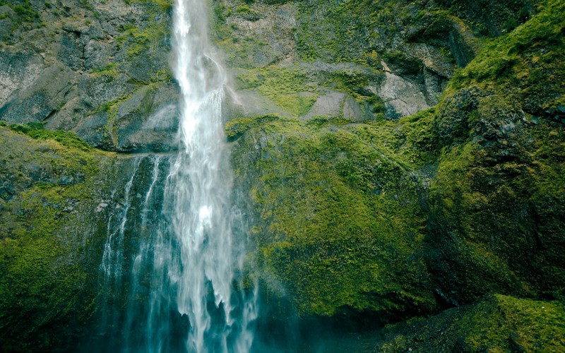 Вид водопада с человеком, стоящим перед ним (водопад мультномах, multnomah falls, водопад, водные ресурсы, водоем)