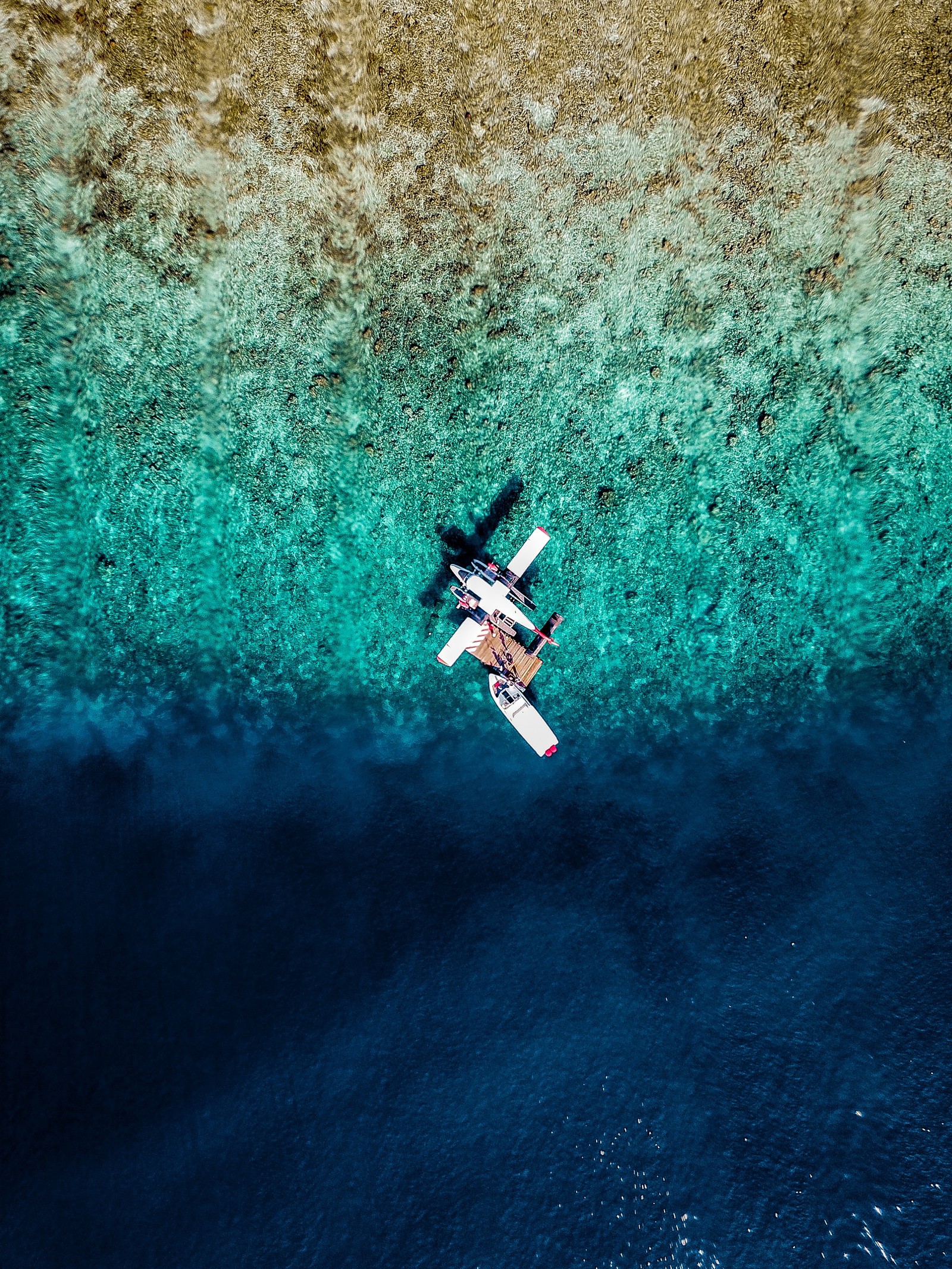 Aerial view of a boat in the middle of the ocean (airplane, water, blue, extreme sport, turquoise)