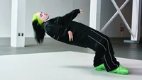 Billie Eilish en una pose dinámica, mostrando su estilo y energía únicos.