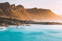 Playa de alta montaña iluminada por el sol con aguas azules y majestuosas montañas