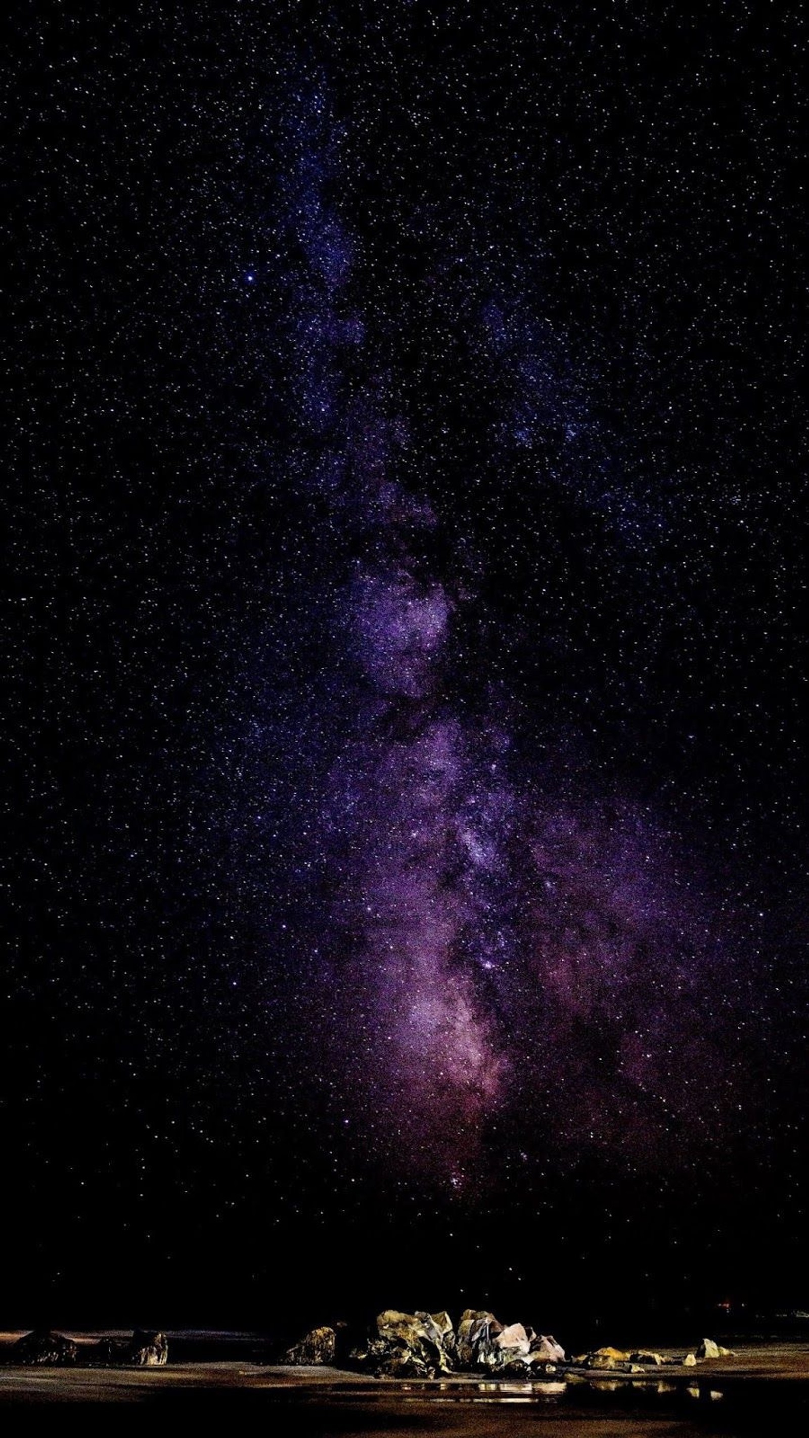 Uma vista de um campo com um monte de pedras sob um céu estrelado (noite, estrelas, paisagem)