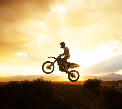 Silhouettierter Motocrossfahrer gegen einen feurigen Sonnenuntergang