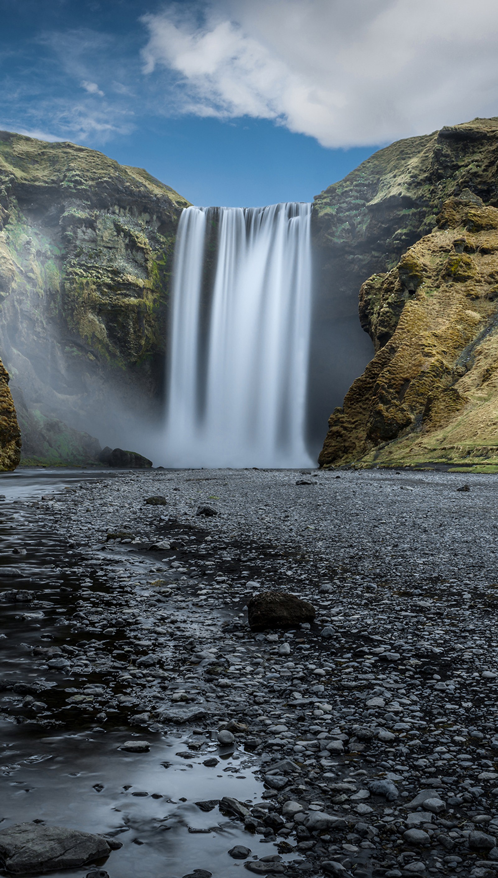 Hay una cascada que fluye sobre una colina rocosa (paisaje, naturaleza, cascada)