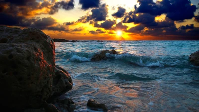 Sunset Over Rocky Shoreline: Waves Crashing Against the Coast