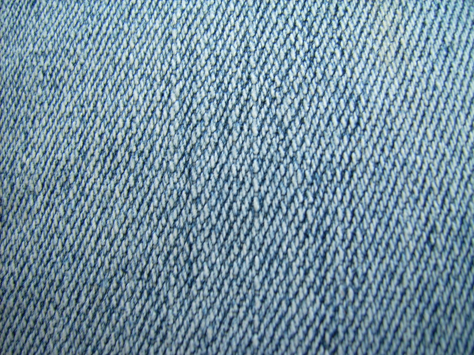 A close up of a blue jean's jeans with a small hole in the middle (jeans, denim, textile, clothing, blue)