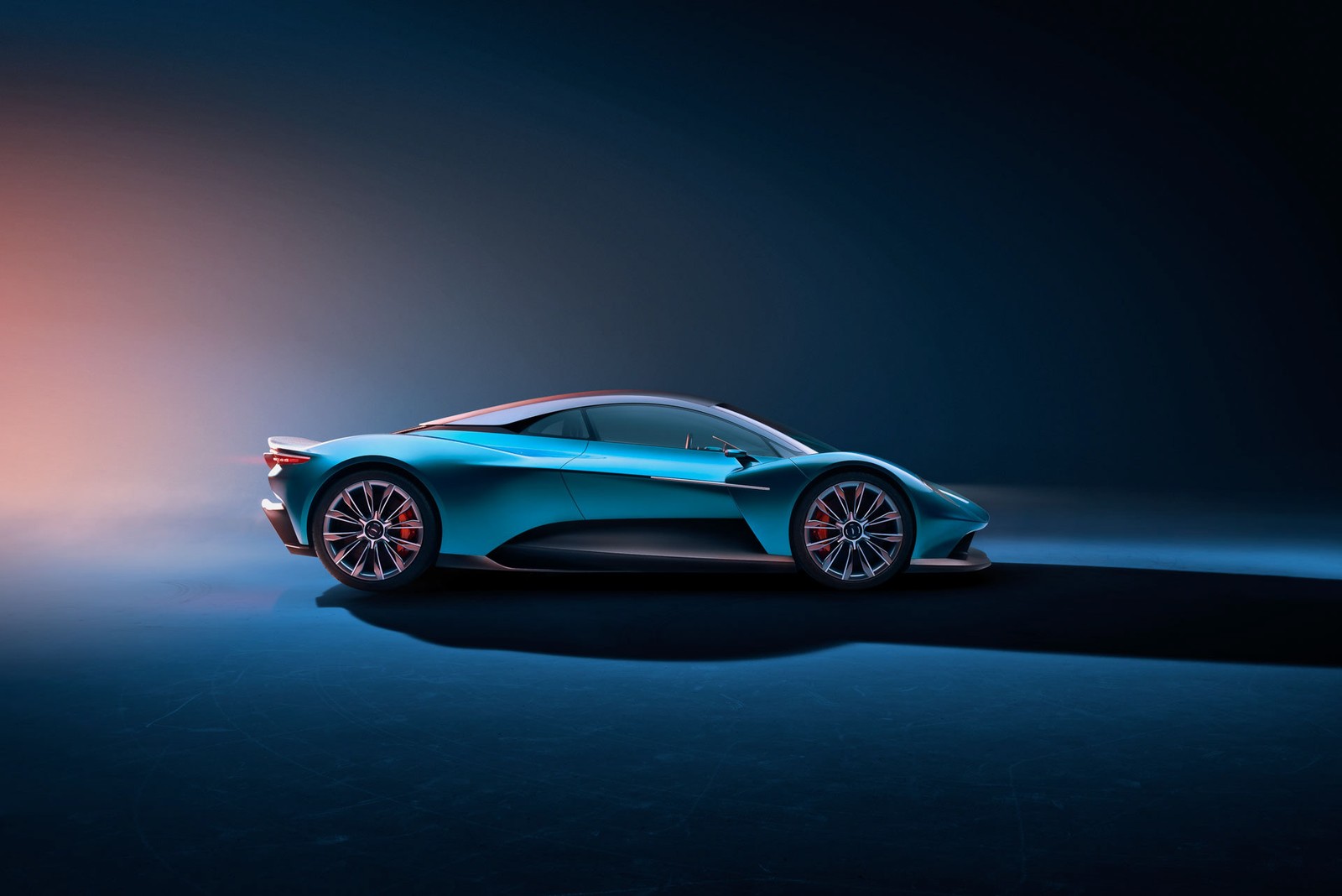 A blue sports car in a dark room with a light on (race car, aston martin, car, sports car, concept car)