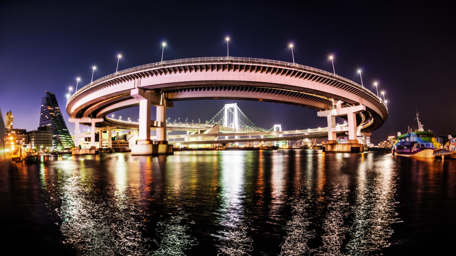 Uma vista de uma ponte sobre um corpo d'água à noite (ponte arco íris, noite, ponte, marco, reflexo)