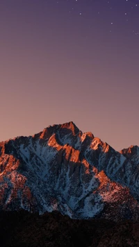 Montaña majestuosa al anochecer bañada en resplandor y cielos estrellados