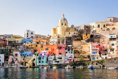 Colorido pueblo costero con edificios vibrantes y un puerto deportivo bajo un cielo despejado.