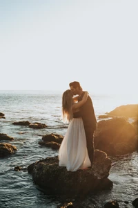 Baiser romantique au coucher du soleil près de l'océan