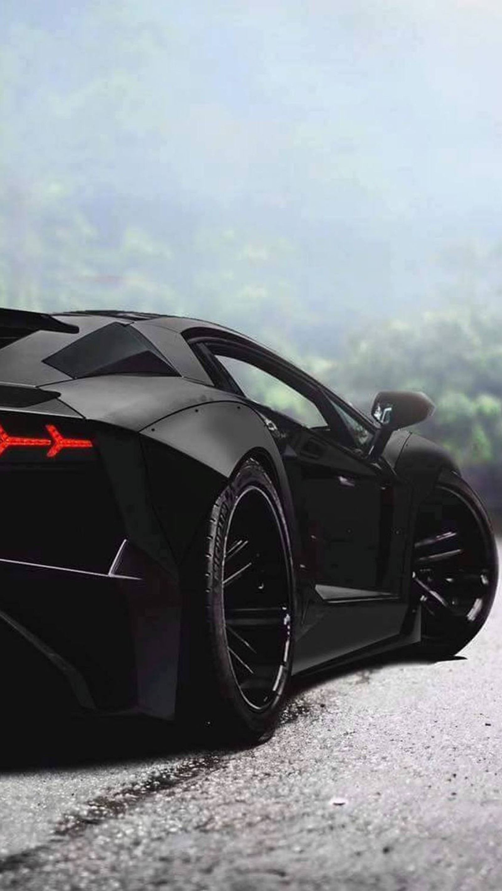 A close up of a black sports car parked on a road (black, car, lamborghini)