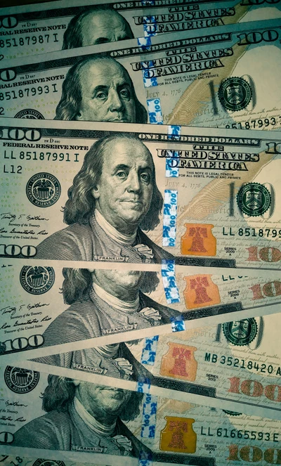 Des piles de billets de 100 dollars avec Benjamin Franklin, montrant la richesse et l'abondance.