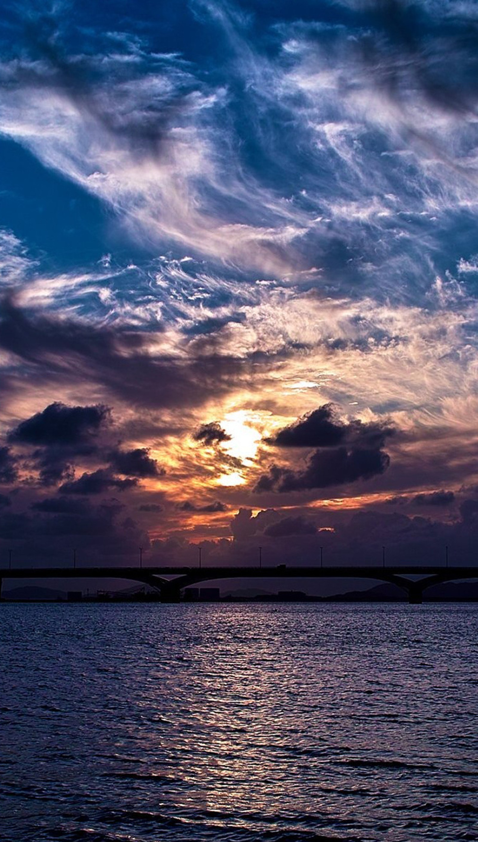 Eine nahaufnahme einer brücke über ein gewässer bei sonnenuntergang (natur, foto, himmel)