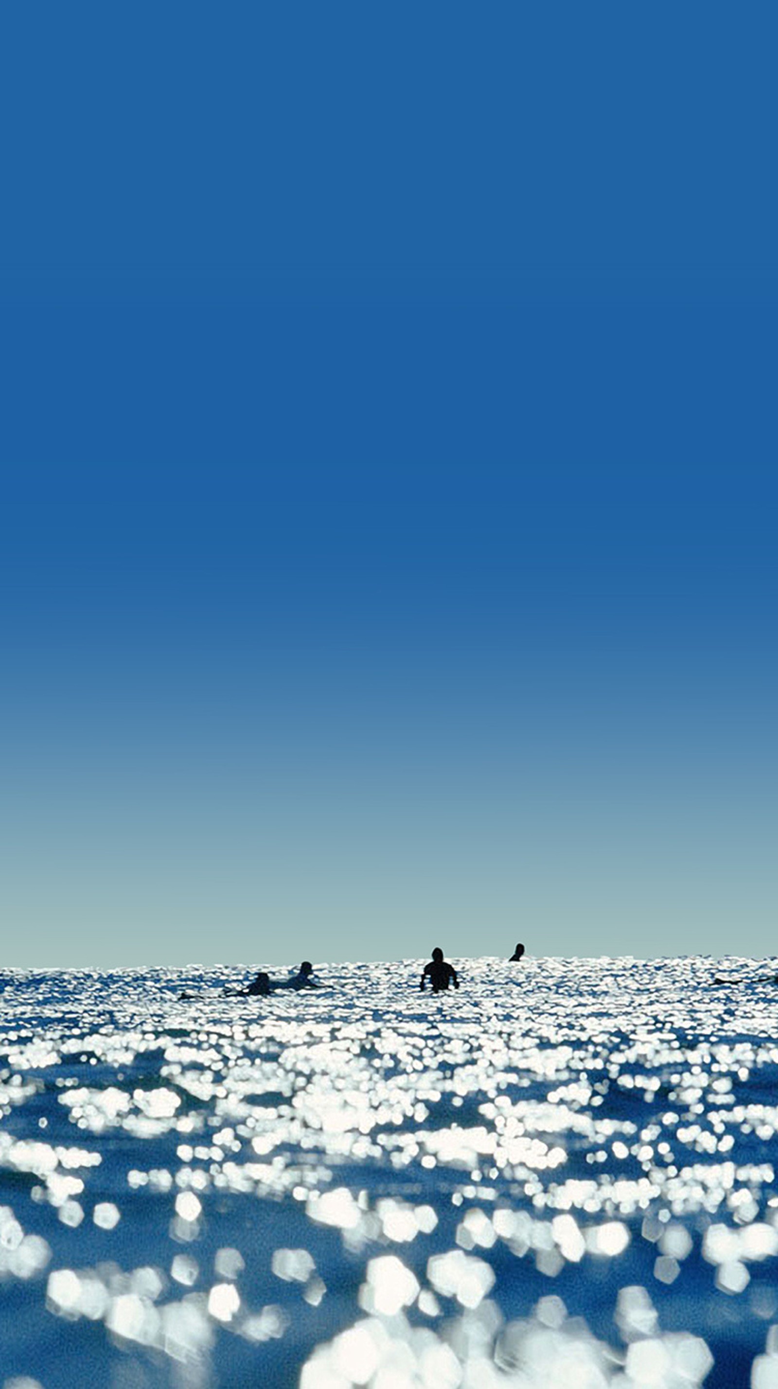 Los surfistas están en el océano con sus tablas en el agua (azul, mar, verano, agua)