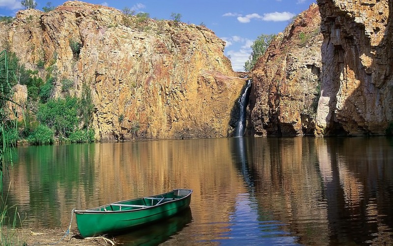 Зеленая лодка стоит на воде рядом с водопадом (природа, отражение, вода, скала, озеро)