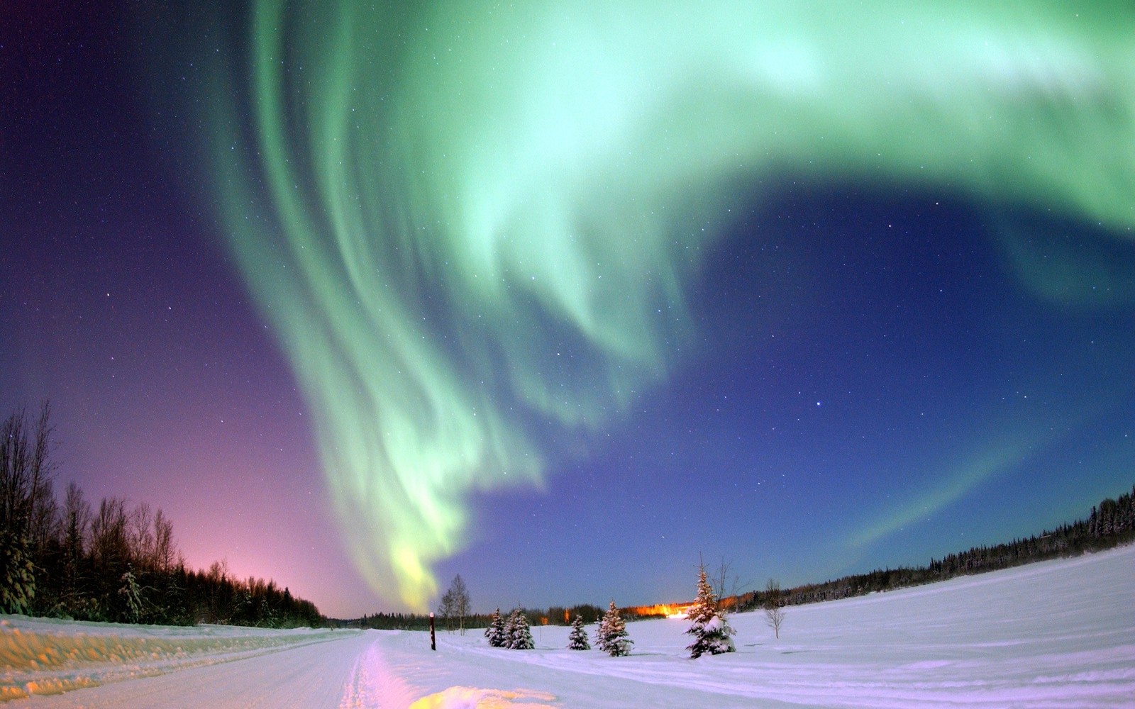 Vue d'une route enneigée avec une aurore boréale verte et violette (aurore, régions polaires de la terre, neige, nuage, gel)