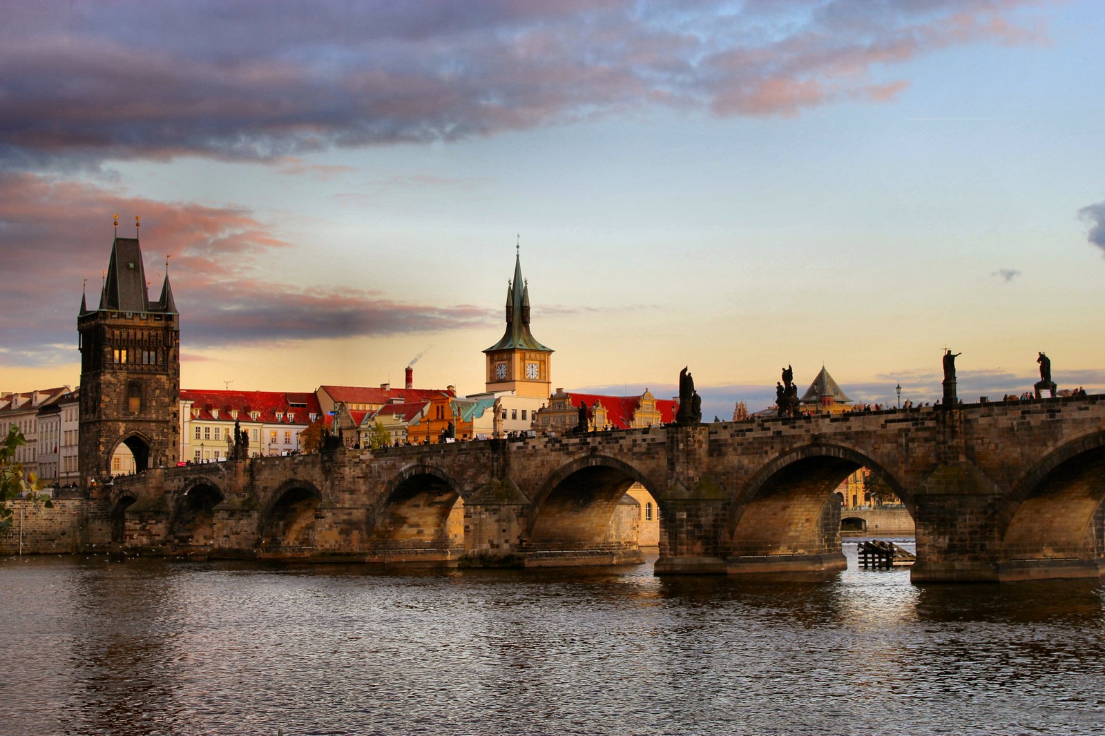 Vista arafed de uma ponte com uma torre do relógio e uma torre do relógio (ponte carlos, charles bridge, vltava, marco, flúmen)