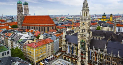 Aerial view of Munich's iconic cityscape featuring historic towers and vibrant rooftops.