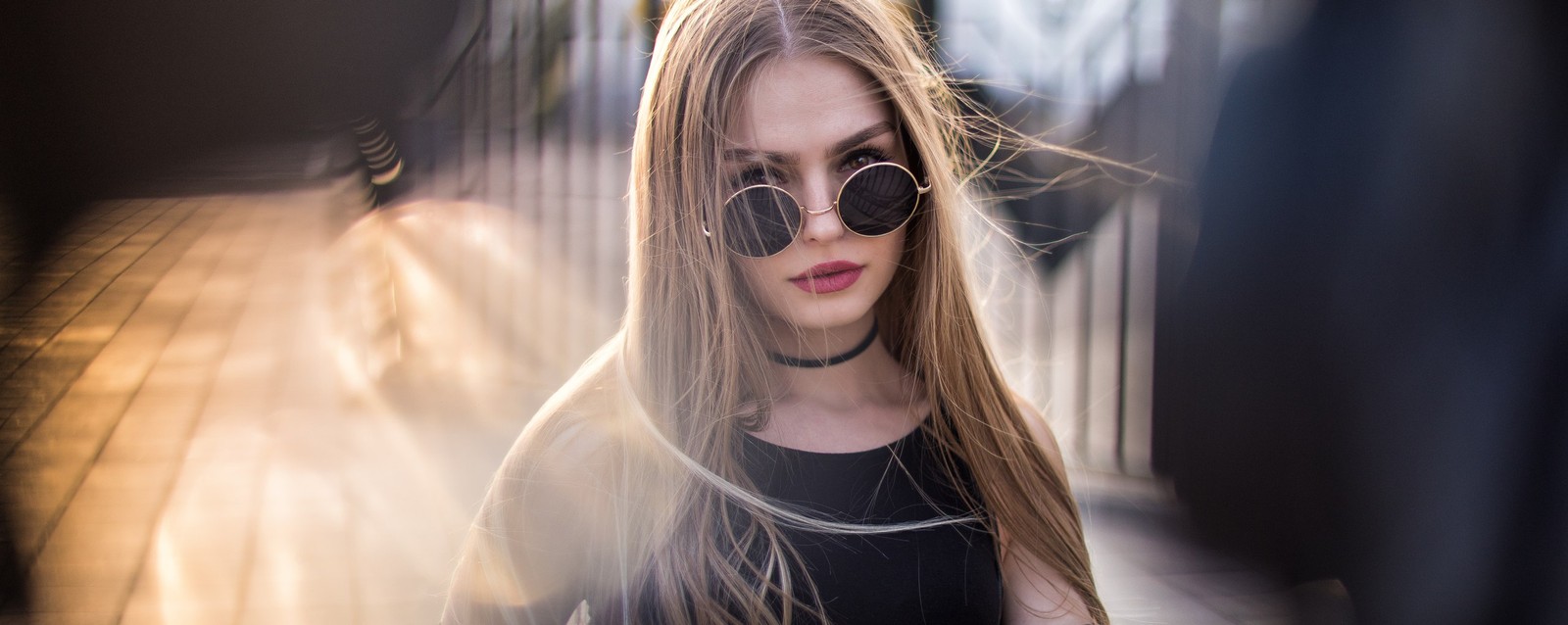 Un primer plano de una mujer con gafas de sol mirando su teléfono (canción, gafas, cabello, gafas de sol, rubio)