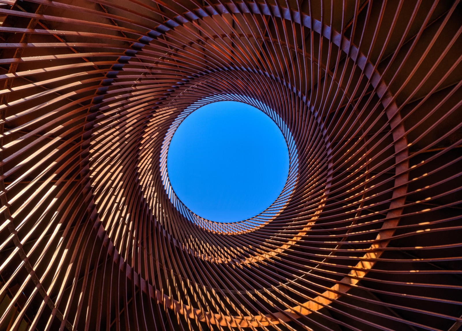 Nahaufnahme einer runden holzstruktur mit blauem himmel im hintergrund (metall design, zirkular, muster, blauer himmel, in den himmel schauen)