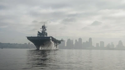 United States Navy Aircraft Carrier Approaching Urban Skyline