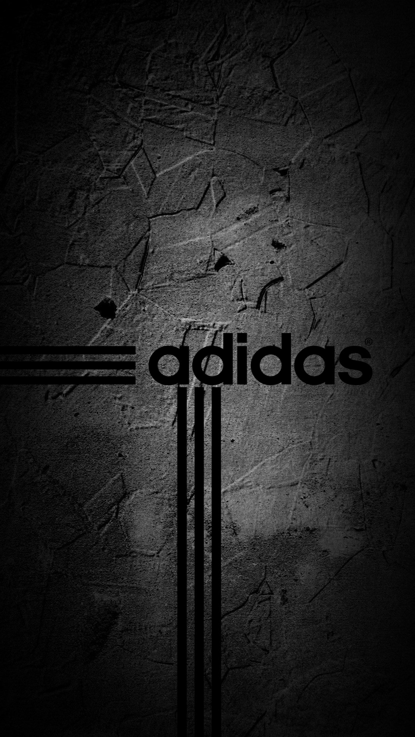 A black and white photo of a wall with the word adidas on it (adidas, logo)