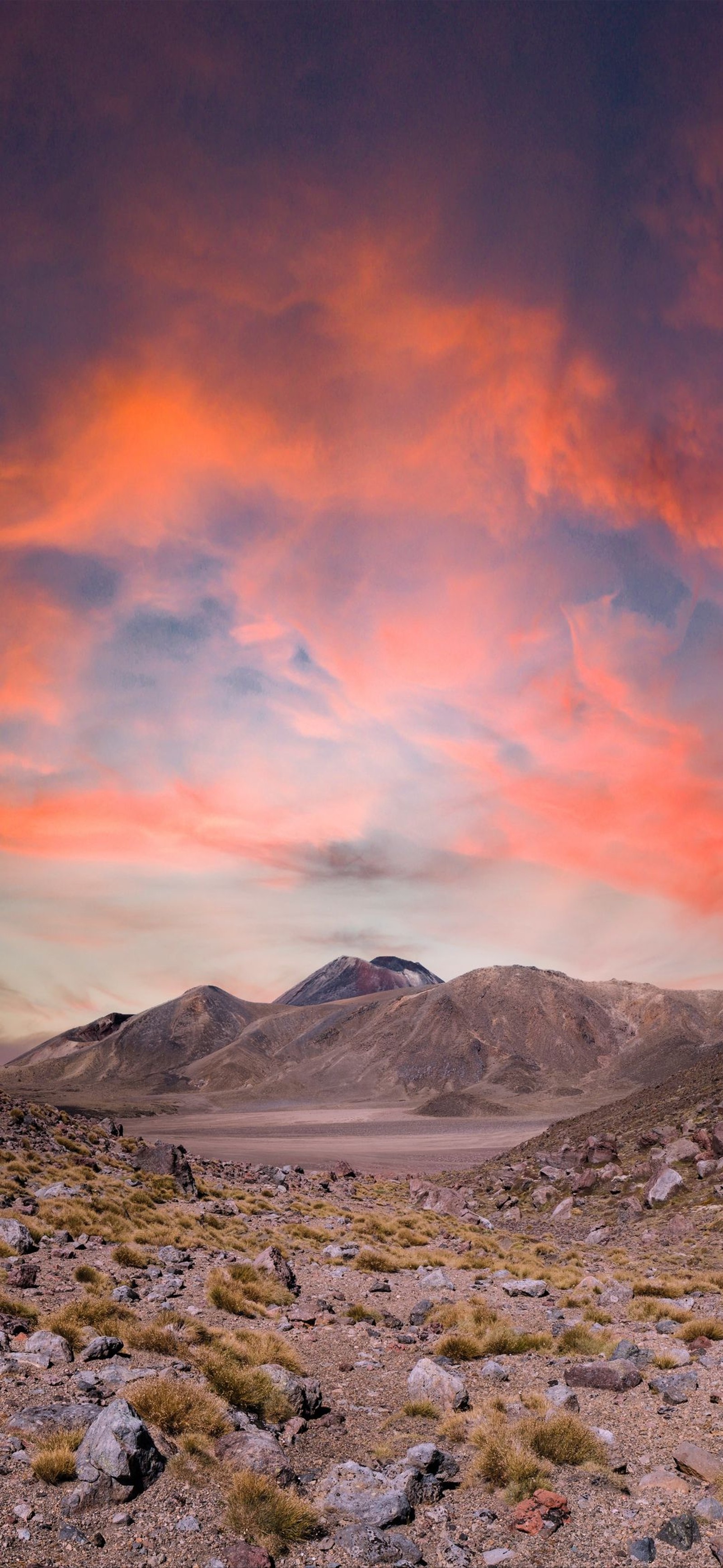 Il y a un ciel rouge au-dessus d'une montagne et d'un champ. (nuage, volcan, mordor, montagne, nature)