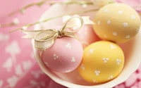 Huevos de Pascua en tonos pastel con cintas decorativas en un tazón