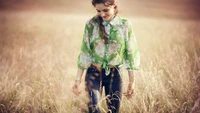 Mujer feliz en la naturaleza vistiendo una blusa floral y disfrutando de la luz del sol