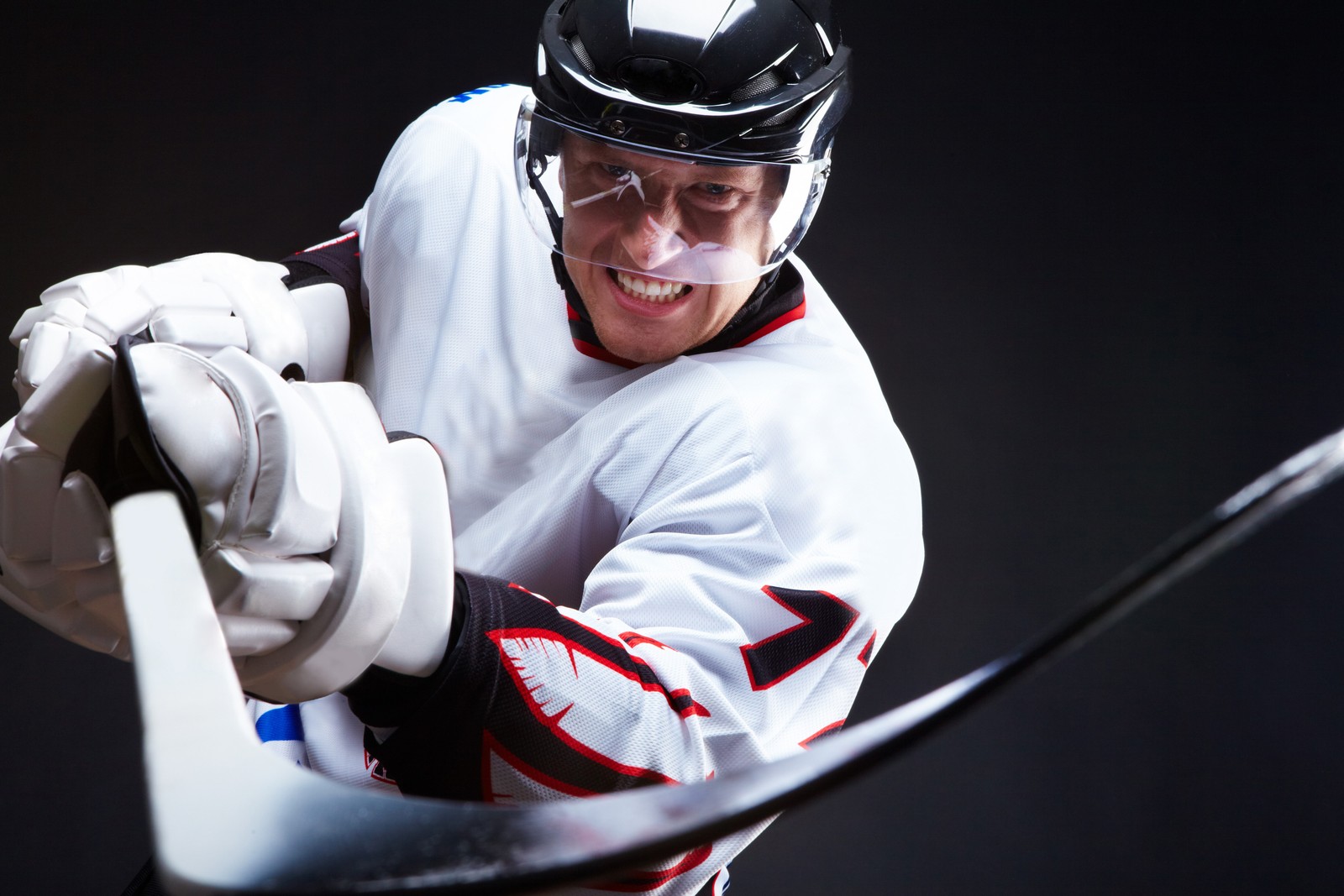 Arafed hockey player in white and black uniform holding a hockey stick (ice hockey, hockey, hockey puck, team sport, hockey stick)