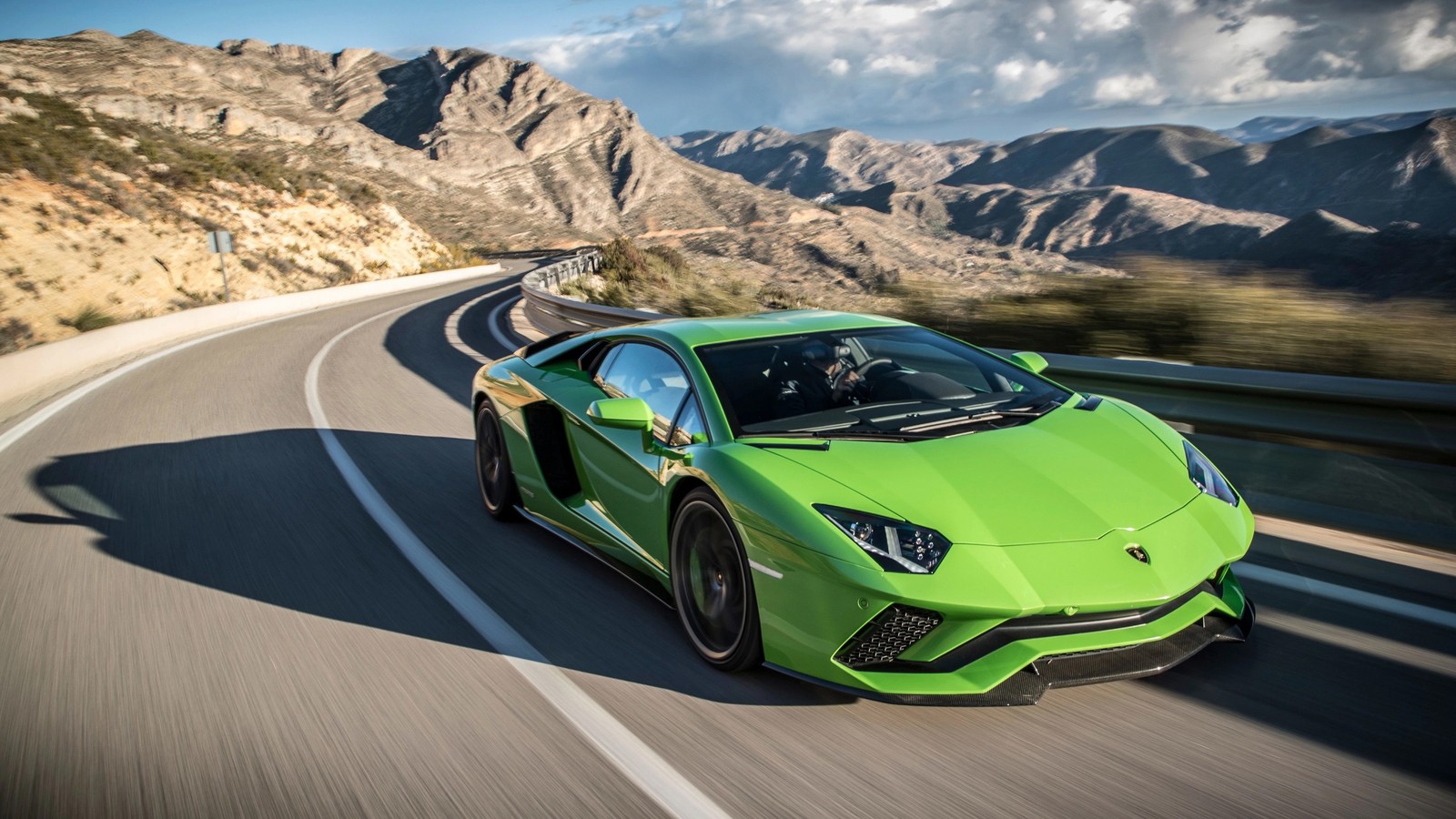 Ein grüner sportwagen fährt eine bergstraße hinunter. (lamborghini, sportwagen, auto, lamborghini gallardo, superauto)