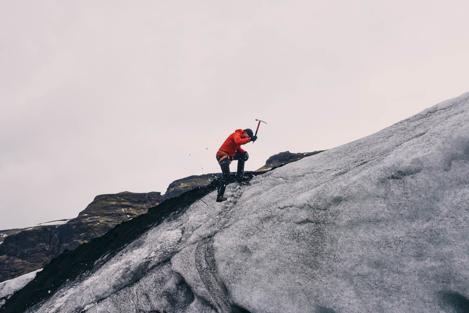 Homem árabe escalando uma montanha íngreme com um bastão (montanhismo, montanhista, aventura, formas montanhosas, recreação ao ar livre)