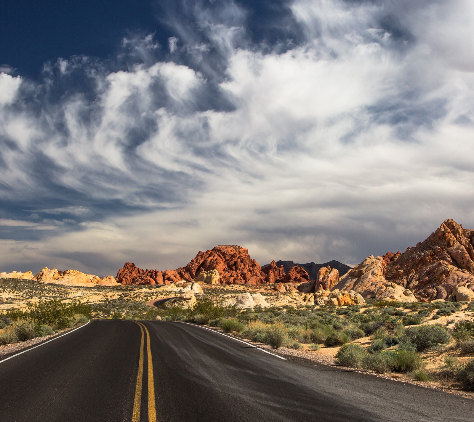 Route arafée dans le désert avec des montagnes et des nuages en arrière-plan (amérique, nuages, las vegas, route, états unis)