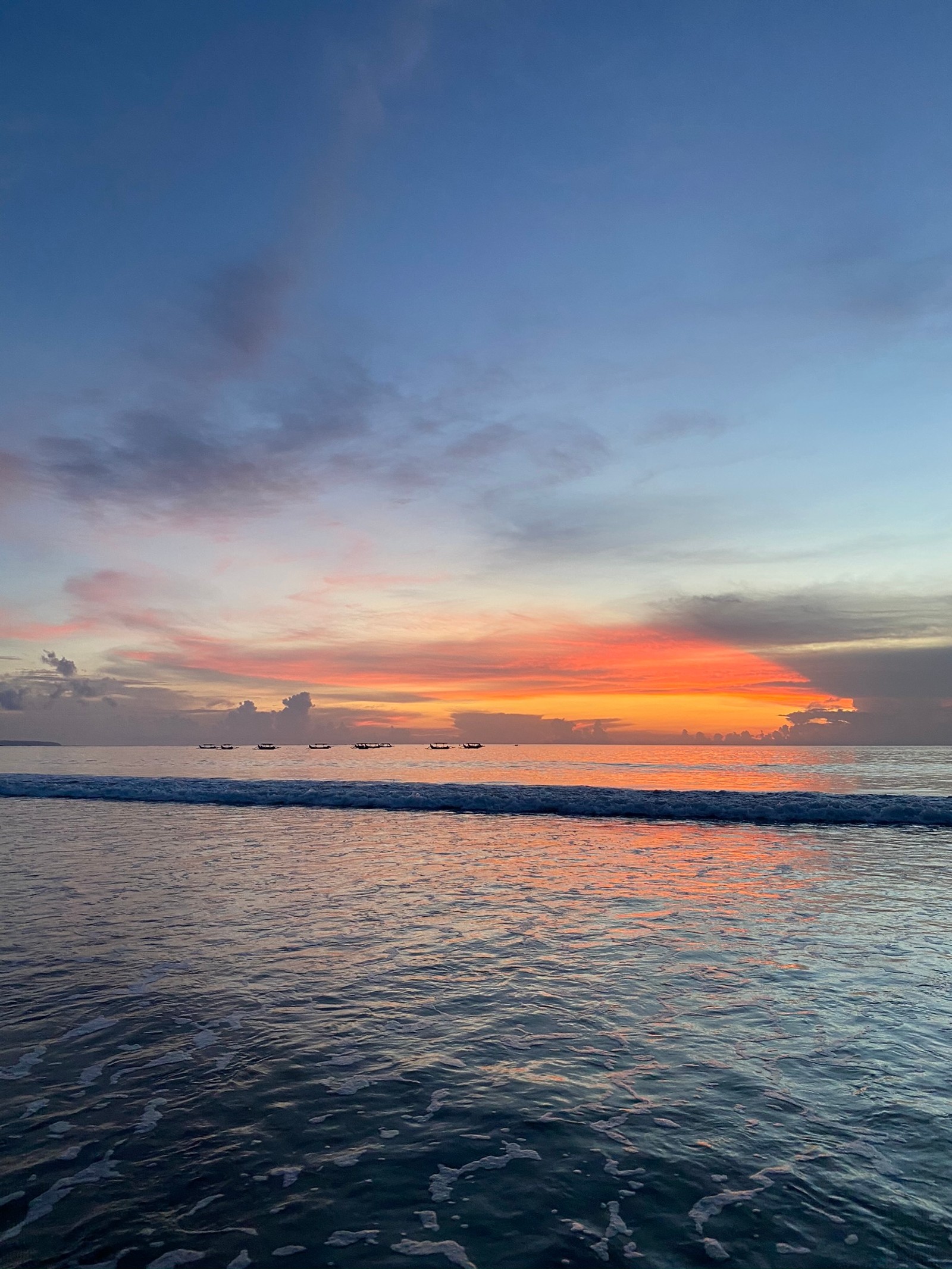 Pôr do sol sobre o oceano com um surfista na água (mar, líquido, nuvem, crepúsculo, recursos hídricos)