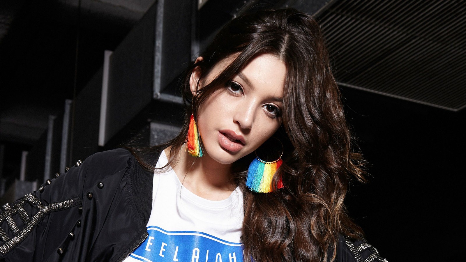 Araffe woman with colorful earrings and a white shirt posing for a picture (celine farach, brunette, model, celebrity, women)