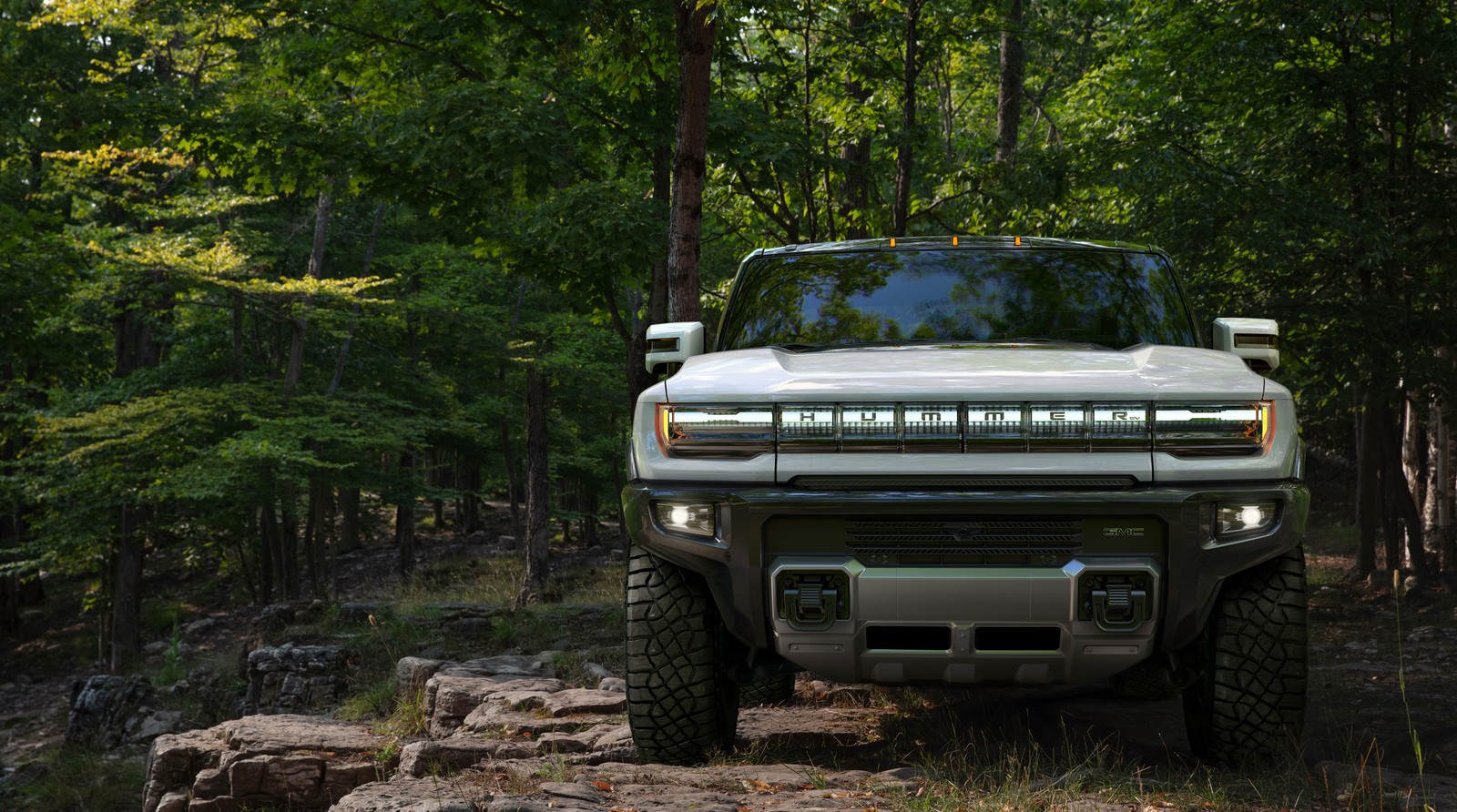 Un camión árabe estacionado en un sendero rocoso en el bosque (gmc hummer ev, suv eléctrico, camiones eléctricos, suv de lujo, bosque)