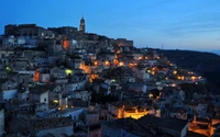 Vista do crepúsculo de uma aldeia montanhosa iluminada ao anoitecer