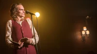 Joaquin Phoenix as the Joker delivering a haunting performance on stage.