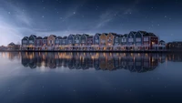 Casas coloridas junto al lago bajo un cielo estrellado de la tarde