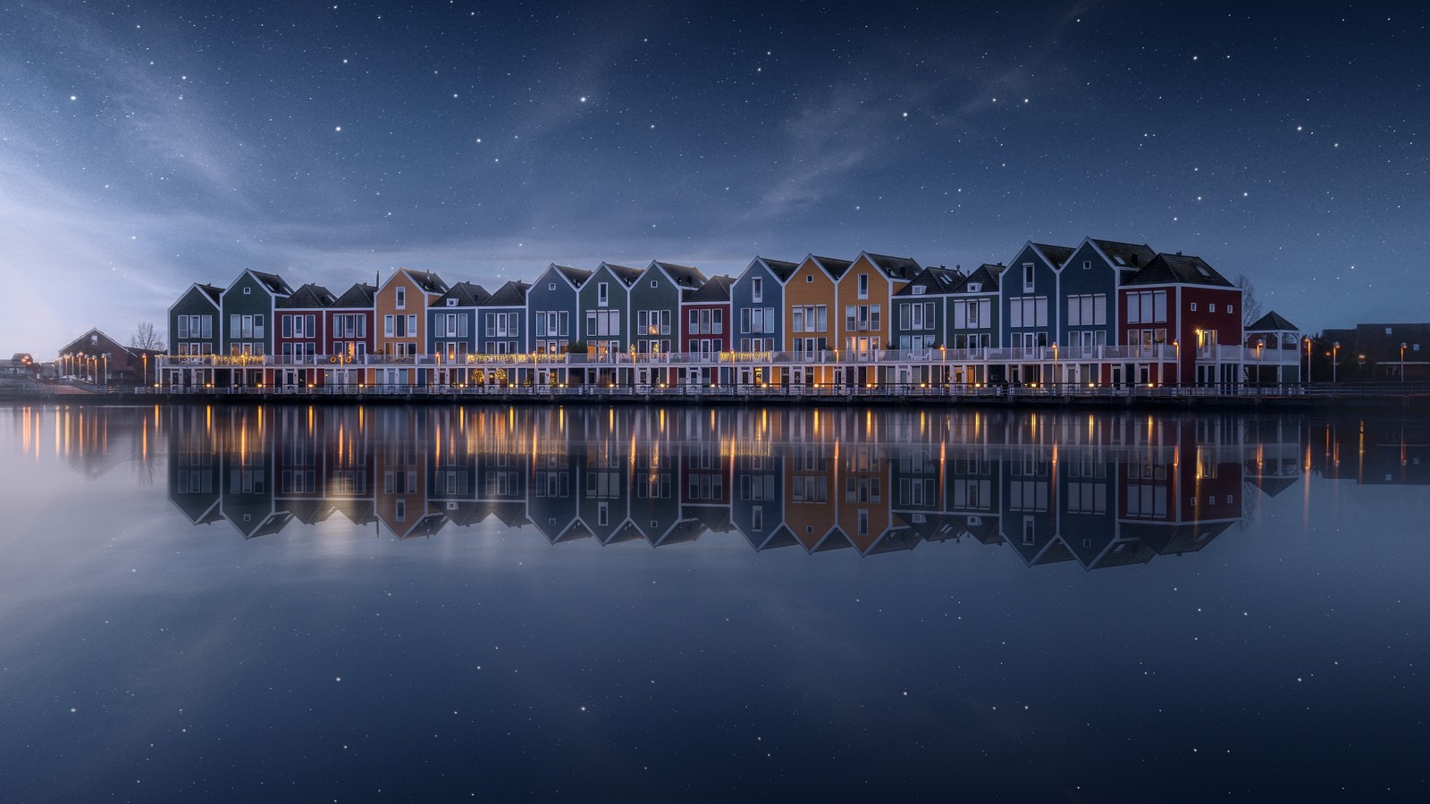 Uma fileira de casas à beira-mar à noite (colorido, margem do lago, casa, arco íris, estrelas no céu)