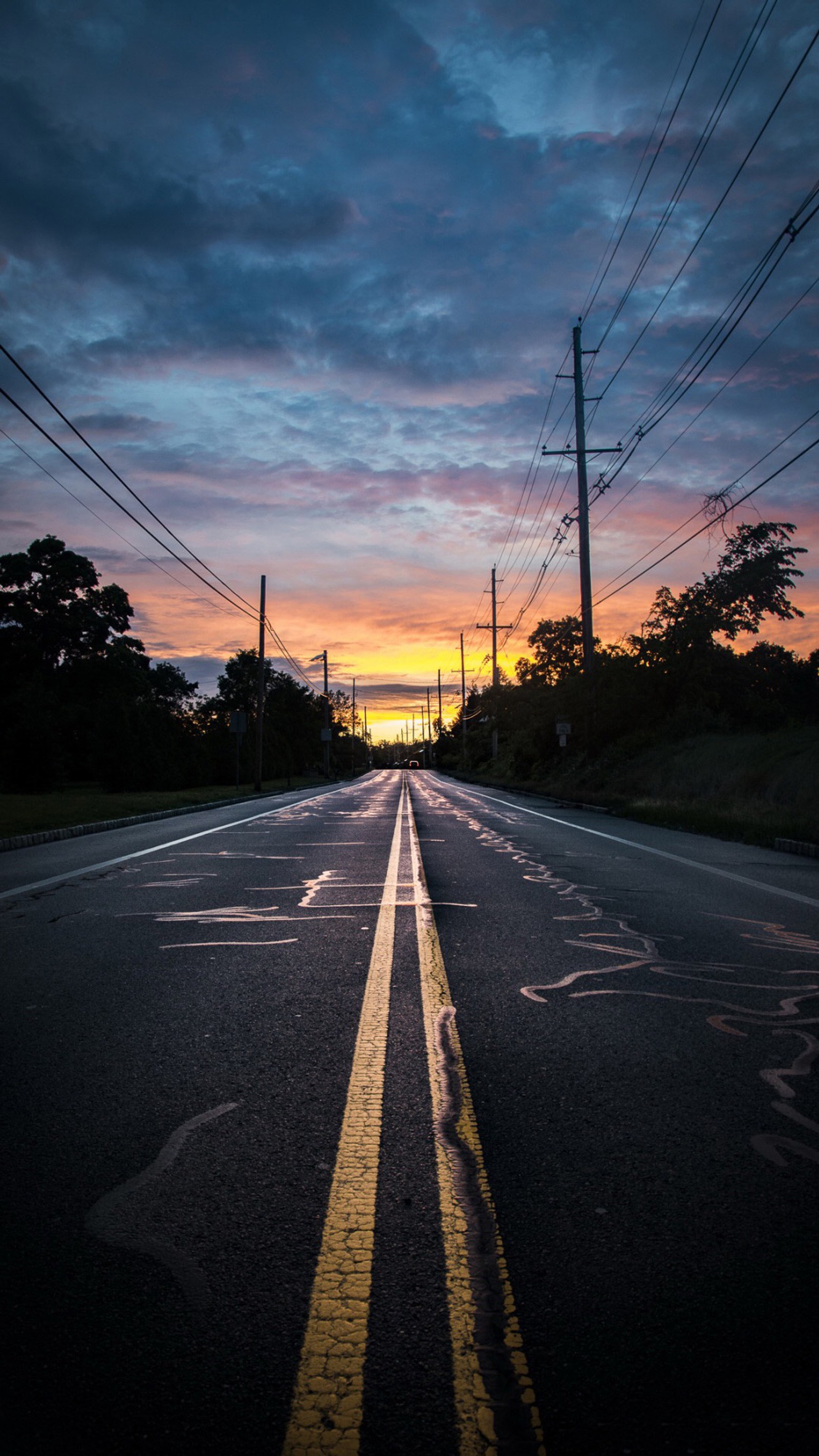 Arafed view of a road with a yellow line on the side (cloud, afterglow, road surface, asphalt, tree)