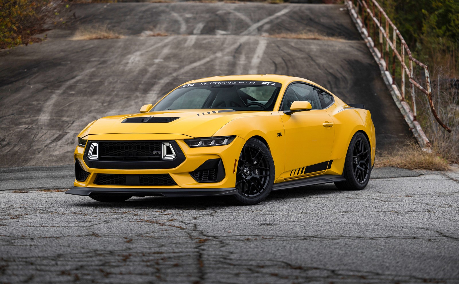 Un mustang amarillo estacionado en una carretera con un puente de fondo (ford mustang, coches amarillos, 2024, 5k, coches)